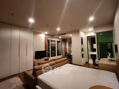 Spacious modern bedroom with cozy seating area and ample storage