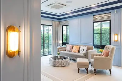 Elegant living room with plush seating and large windows offering garden views.