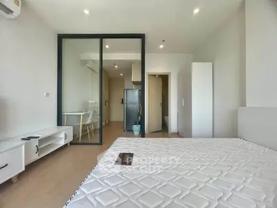 Modern studio apartment with open layout and sleek glass partition
