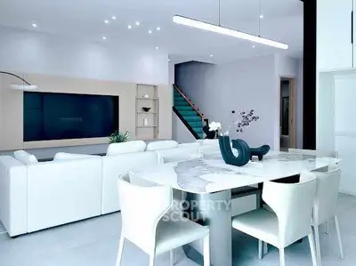 Modern open-plan living room with sleek white furniture and elegant decor