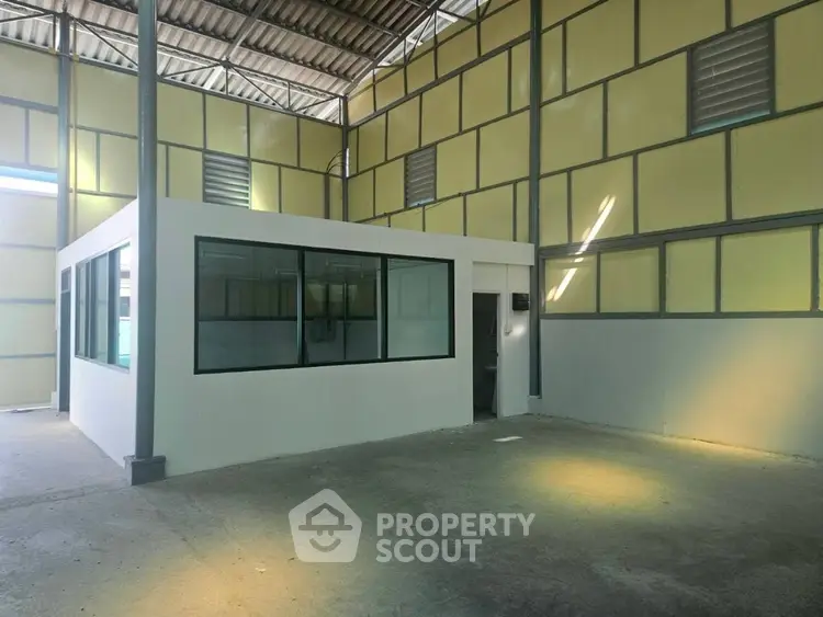 Spacious industrial warehouse interior with high ceilings and office space