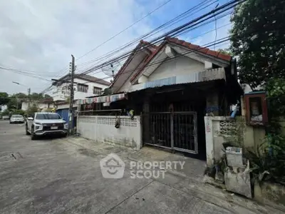 Charming suburban house with gated entrance and driveway in a quiet neighborhood.
