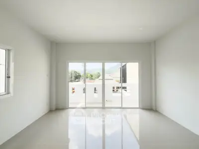 Spacious and bright living room with large windows and glossy tiled floor.