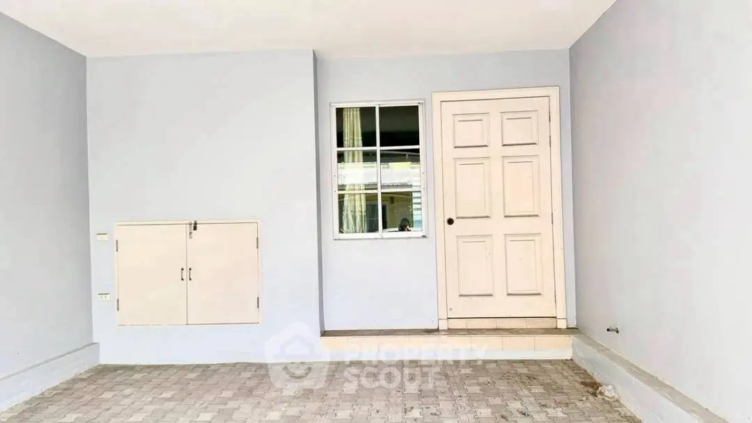 Spacious entrance with paved flooring and modern door design