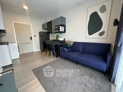 Modern living room with stylish furniture and open kitchen layout in a cozy apartment.