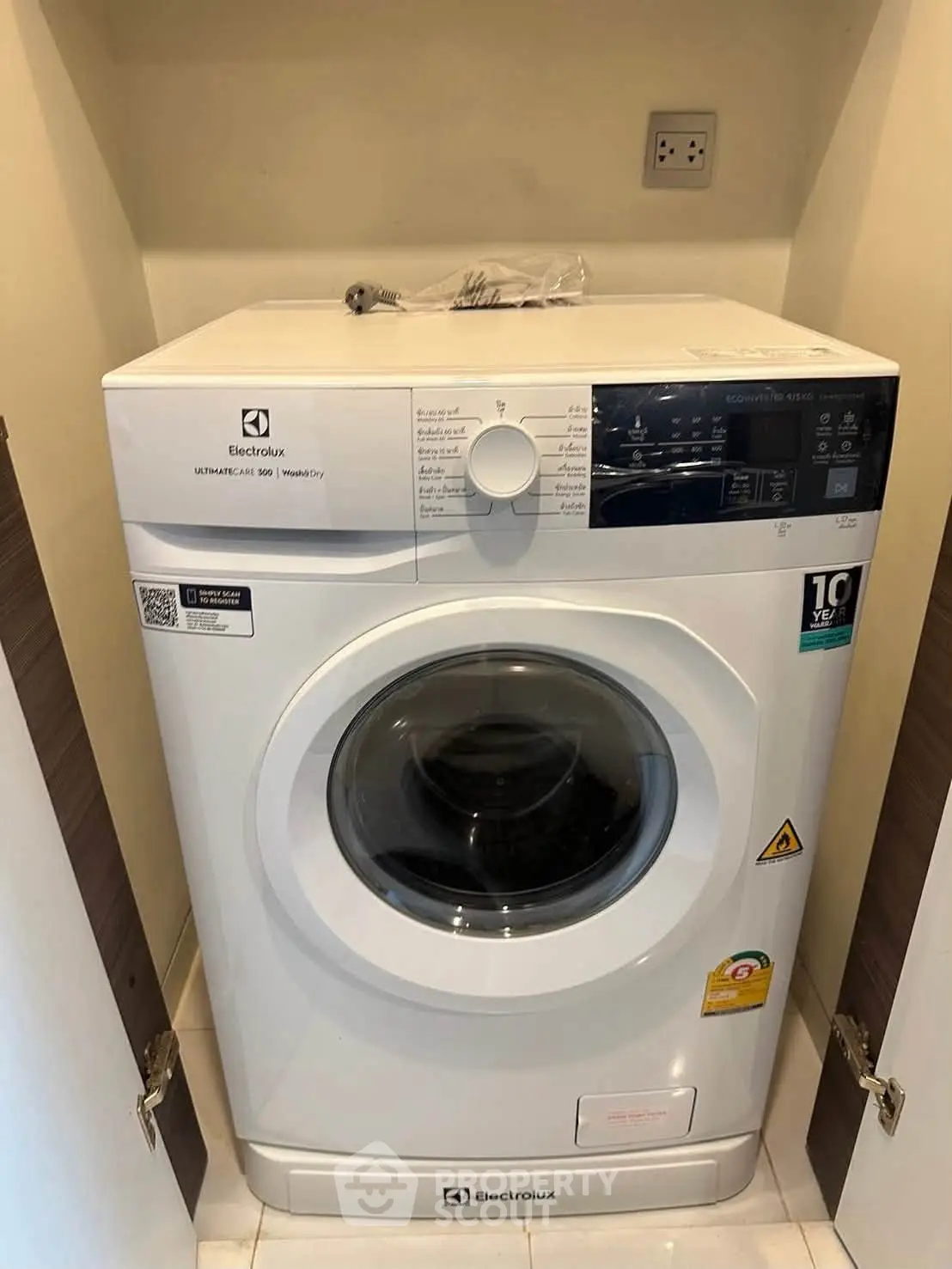 Modern Electrolux washing machine in a compact laundry space, perfect for efficient apartment living.