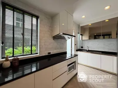 Modern kitchen with sleek black countertops and large window view