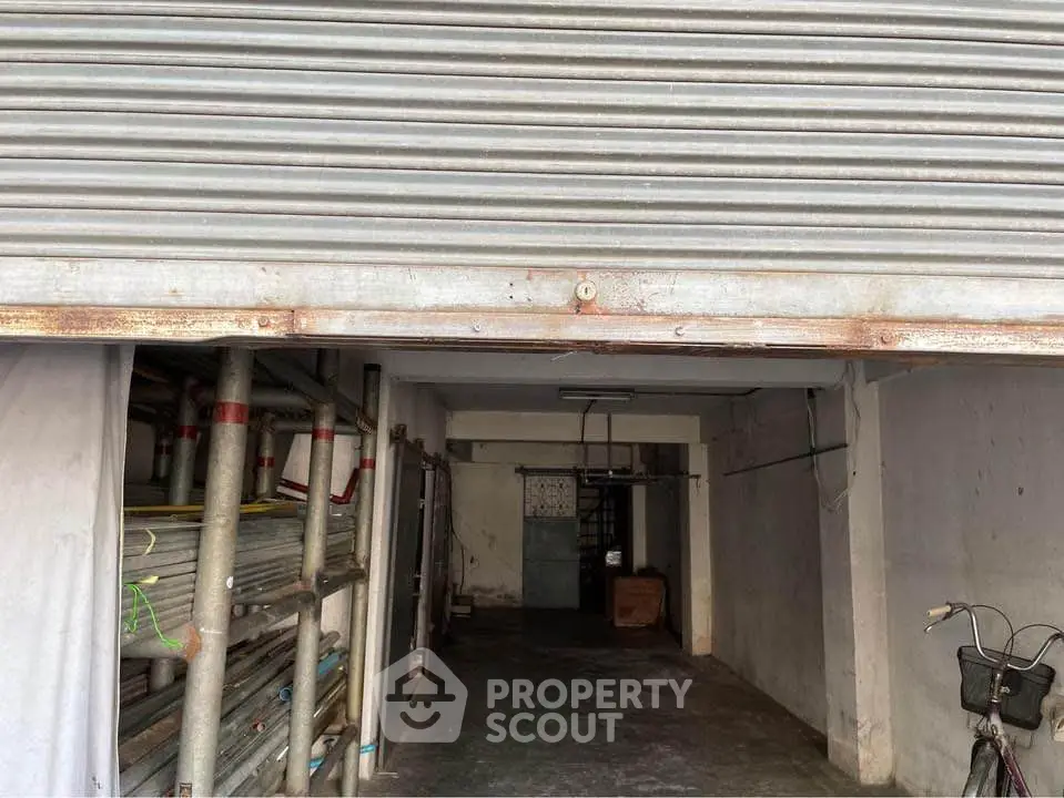 Spacious garage with metal shutter and storage potential, ideal for urban living convenience.