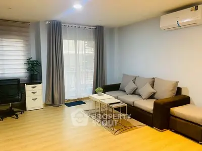 Modern living room with cozy sofa, stylish decor, and natural light from large window.