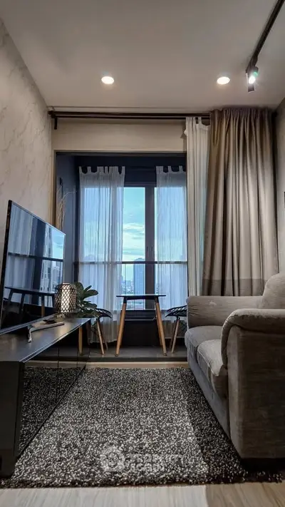 Modern living room with cozy sofa and city view through large window.