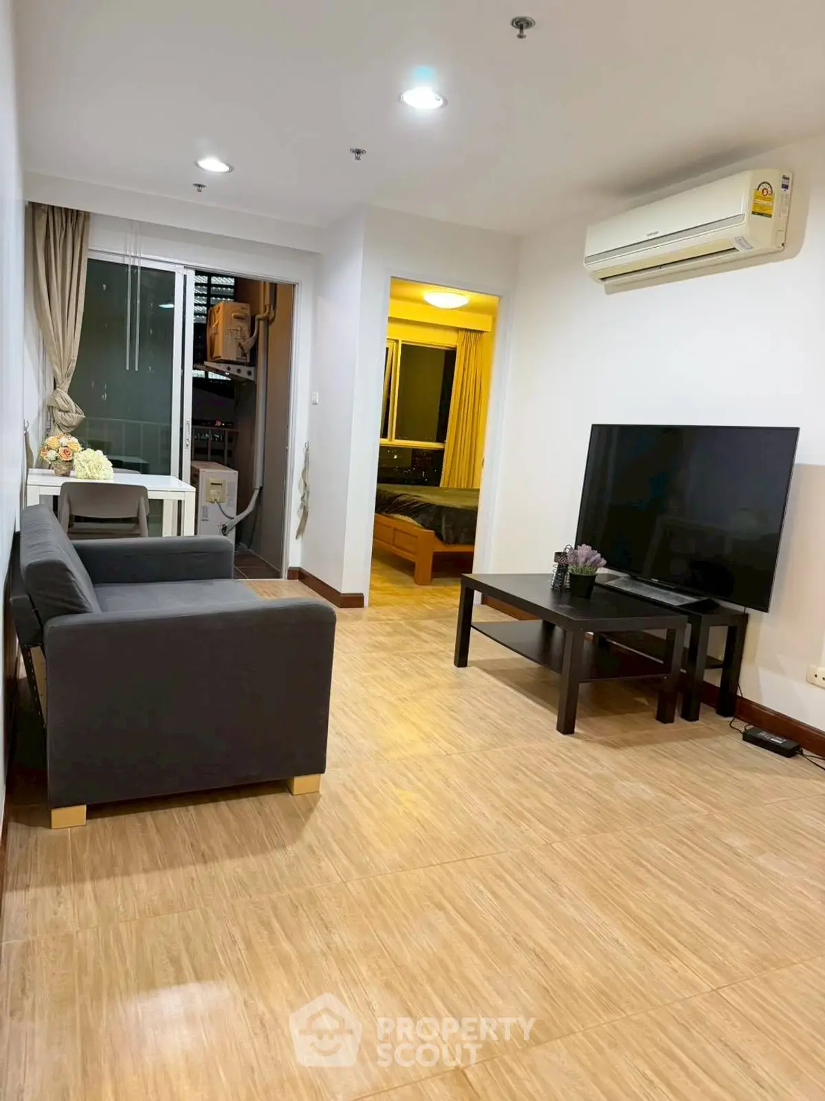 Modern living room with sleek furniture and large TV, featuring a cozy ambiance and stylish decor.