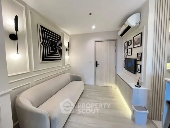 Modern living room with stylish decor and wall-mounted TV, featuring elegant lighting and contemporary furniture.