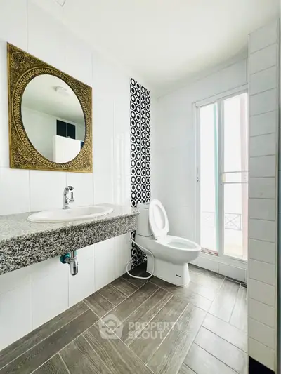 Modern bathroom with stylish mirror and natural light