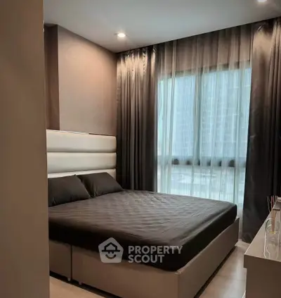 Modern bedroom with large window and elegant curtains in a stylish apartment.