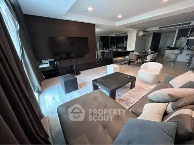 Luxurious modern living room with sleek furniture and open kitchen layout, perfect for entertaining.