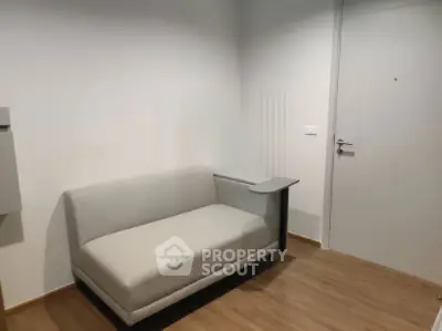 Modern minimalist interior with sleek sofa and wooden flooring in a cozy living space.
