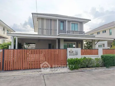 Modern two-story house with stylish facade and gated entrance in suburban neighborhood.
