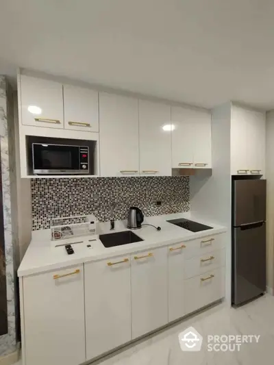 Modern kitchen with sleek white cabinets and mosaic backsplash