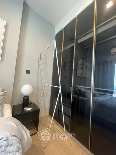 Modern bedroom with sleek mirrored wardrobe and stylish decor