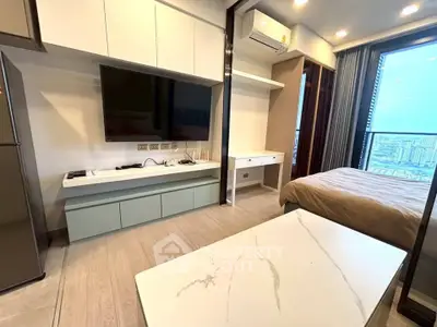 Modern studio apartment with sleek design and city view, featuring a wall-mounted TV and air conditioning.