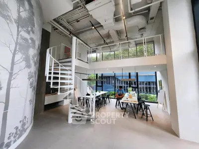 Modern open-plan living area with spiral staircase and large windows