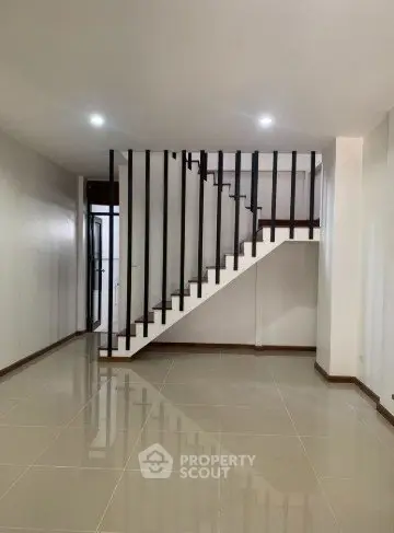 Spacious modern interior with sleek staircase and glossy tiled flooring