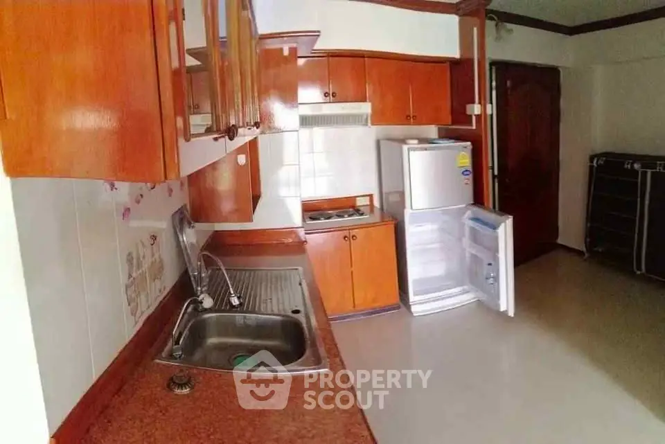Spacious kitchen with wooden cabinets and modern appliances in a cozy apartment.