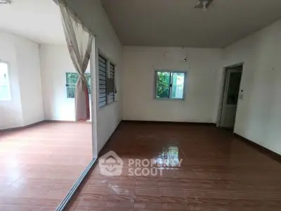 Spacious empty room with tiled flooring and large windows, perfect for customization.