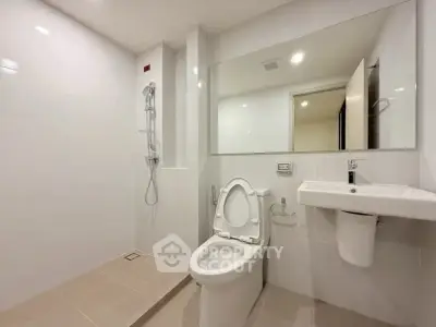 Modern bathroom with sleek fixtures and spacious shower area in a contemporary home.