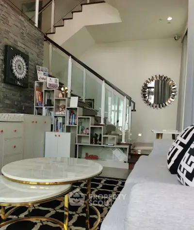 Modern living room with stylish decor, open staircase, and elegant furniture in a contemporary home.
