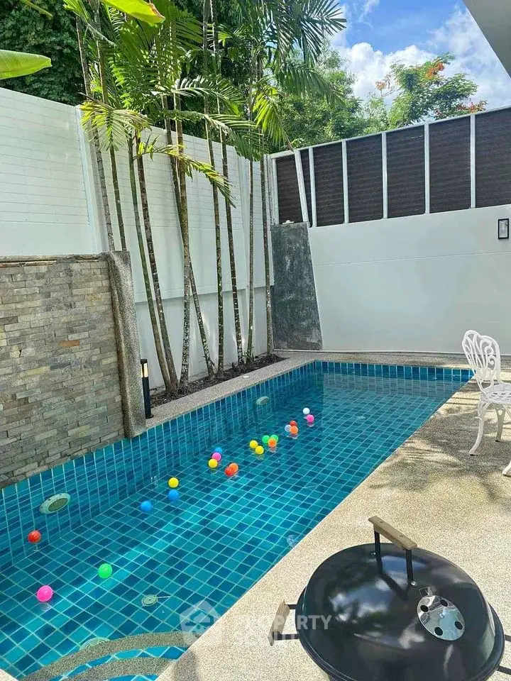 Charming outdoor pool area with vibrant tiles and lush greenery, perfect for relaxation and entertainment.