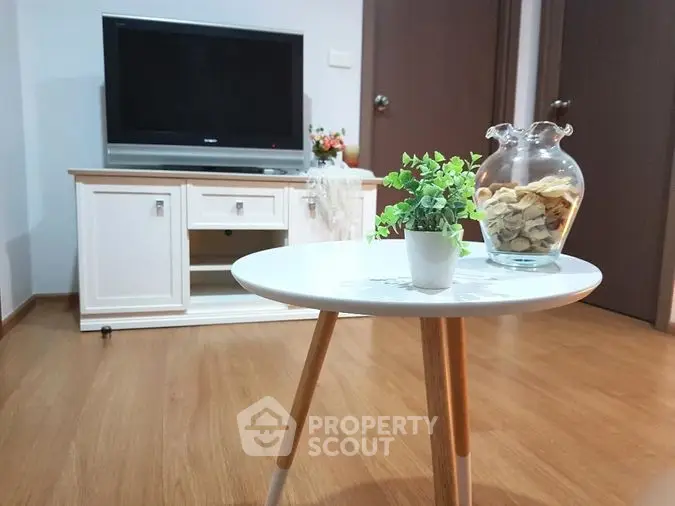 Cozy living room with modern TV stand and stylish coffee table, perfect for relaxation.