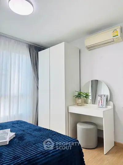 Modern bedroom with stylish vanity, air conditioning, and natural light.