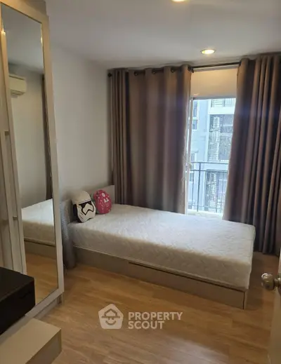 Cozy bedroom with single bed and large window in modern apartment