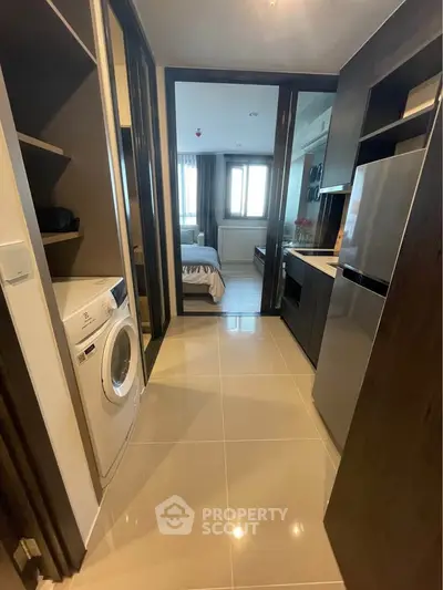Modern apartment hallway with washing machine and view into bedroom