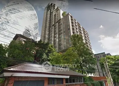 Modern high-rise building with lush greenery and urban skyline view.