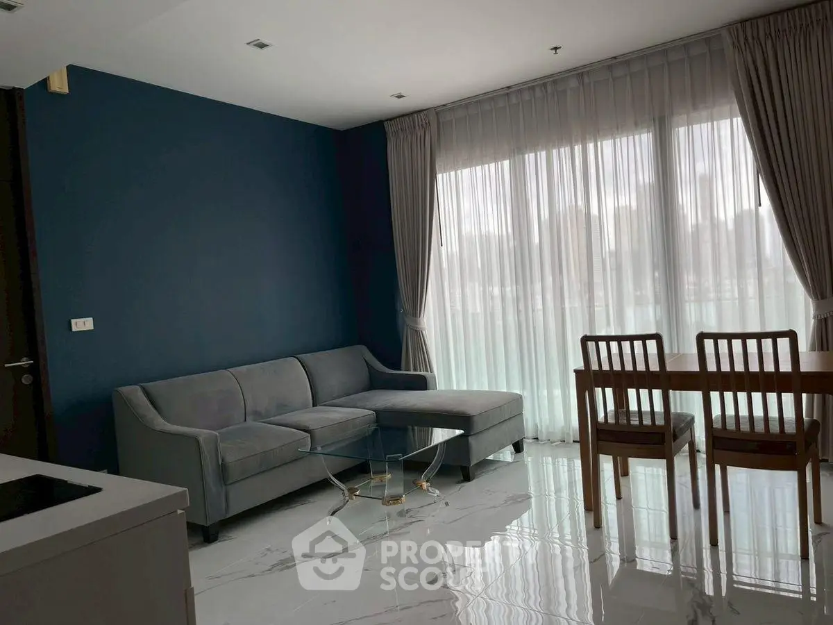 Modern living room with sleek furniture and large window for natural light.