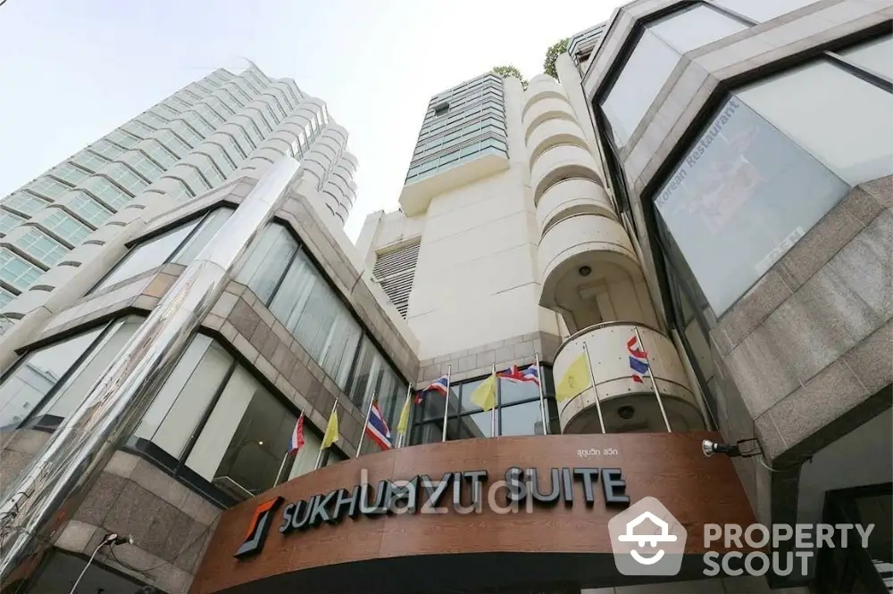 Modern commercial building exterior with flags and signage in urban setting