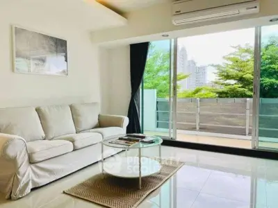 Bright living room with large glass doors opening to a balcony with city views.