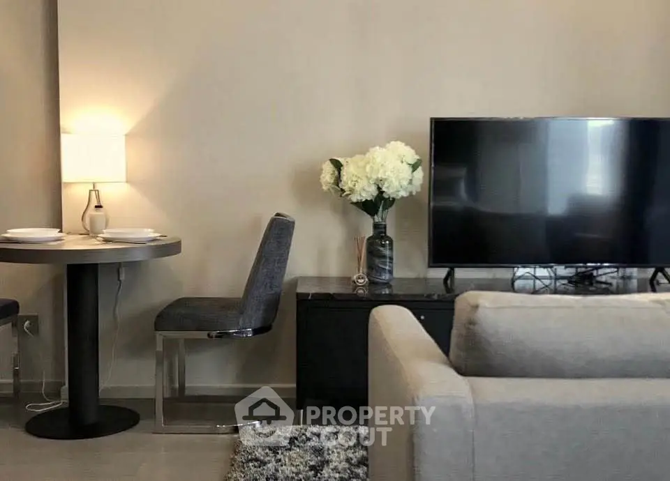 Modern living room with cozy seating, stylish decor, and a sleek TV setup.