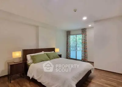 Spacious bedroom with modern decor and large window for natural light