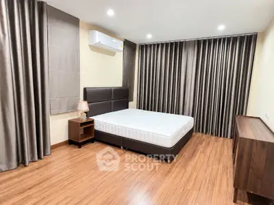 Spacious bedroom with modern furnishings and wooden flooring