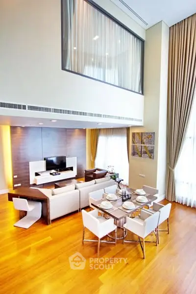 Luxurious double-height living room with elegant dining area and modern decor