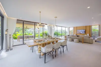 Luxurious open-plan living and dining area with modern decor and garden view.