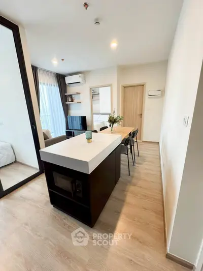 Modern open-plan living room with sleek kitchen island and cozy seating area.