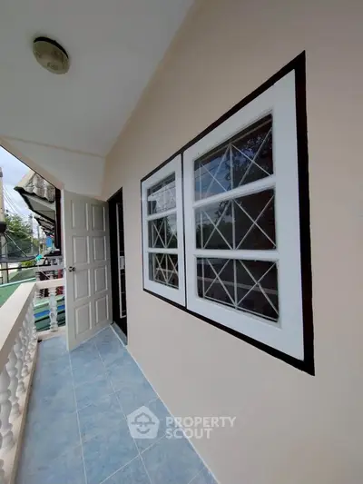 Charming balcony with blue tile flooring and white railing, perfect for relaxation.