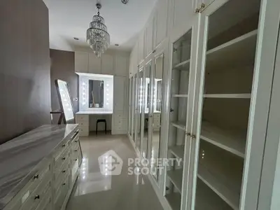 Luxurious walk-in closet with elegant chandelier and ample storage space