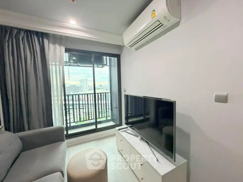 Modern living room with balcony view, featuring sleek furniture and air conditioning.