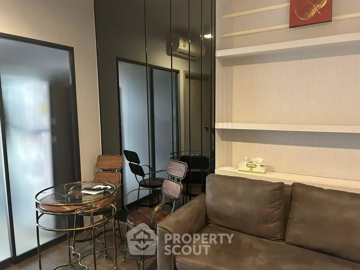 Modern living room with stylish furniture and glass dining table in cozy apartment.