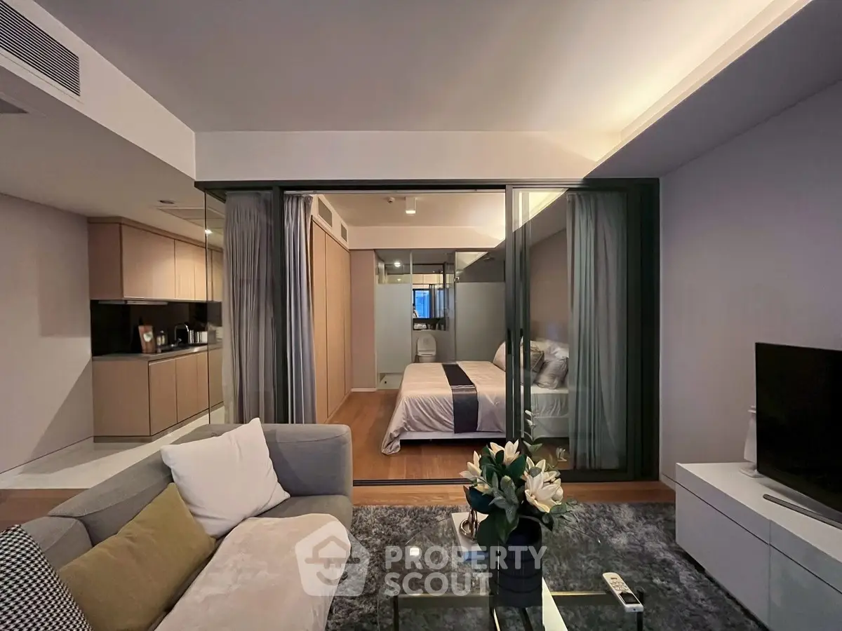 Modern open-plan living room with cozy bedroom view and stylish decor